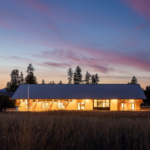 Exterior view of Winthrop Library, showcasing a contemporary architectural design with a striking facade featuring large glass windows and a unique roofline. The building is set in a landscaped area with greenery and pathways, creating an inviting atmosphere for visitors. The design emphasizes openness and accessibility, reflecting the library's role as a community hub.