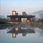A modern Northwest-style home with large windows, natural wood siding, and a sleek, contemporary design, surrounded by lush greenery.