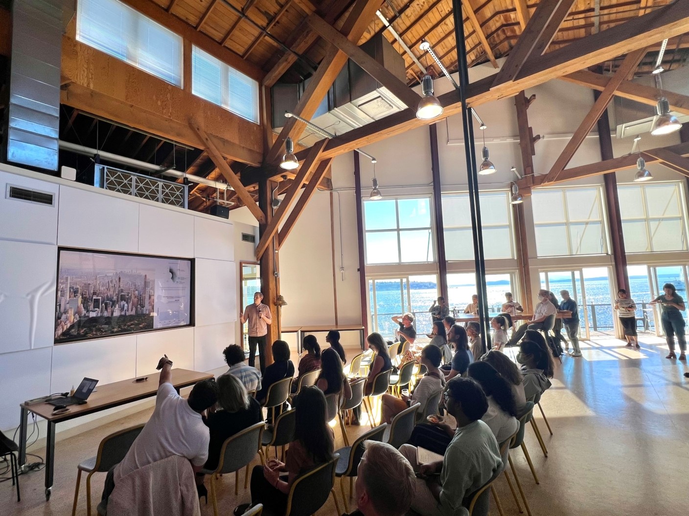 A beautiful reception hall with someone giving a presentation to about 30 people