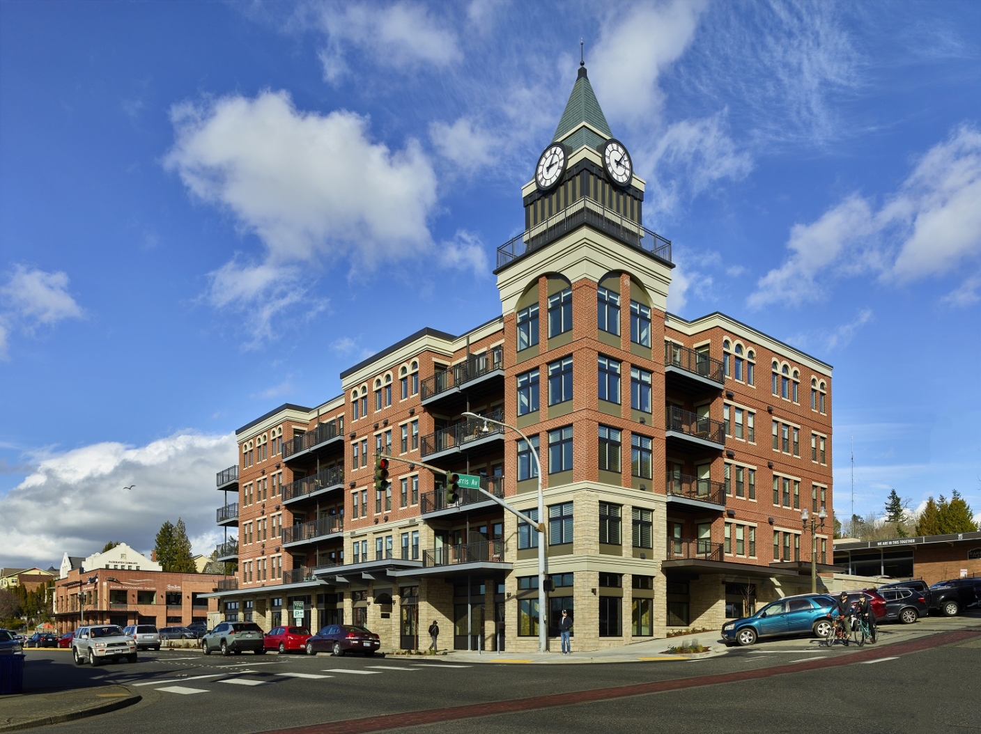 Urban, mixed-use building clad in brick on corner lot with clocktower placed at center